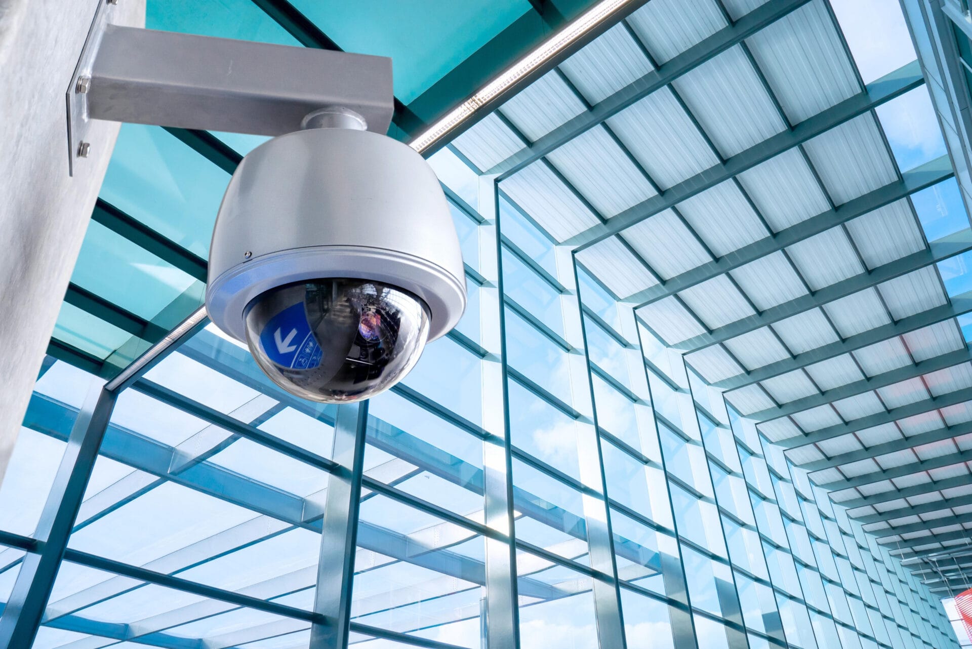 Dome security camera installed in a modern glass building