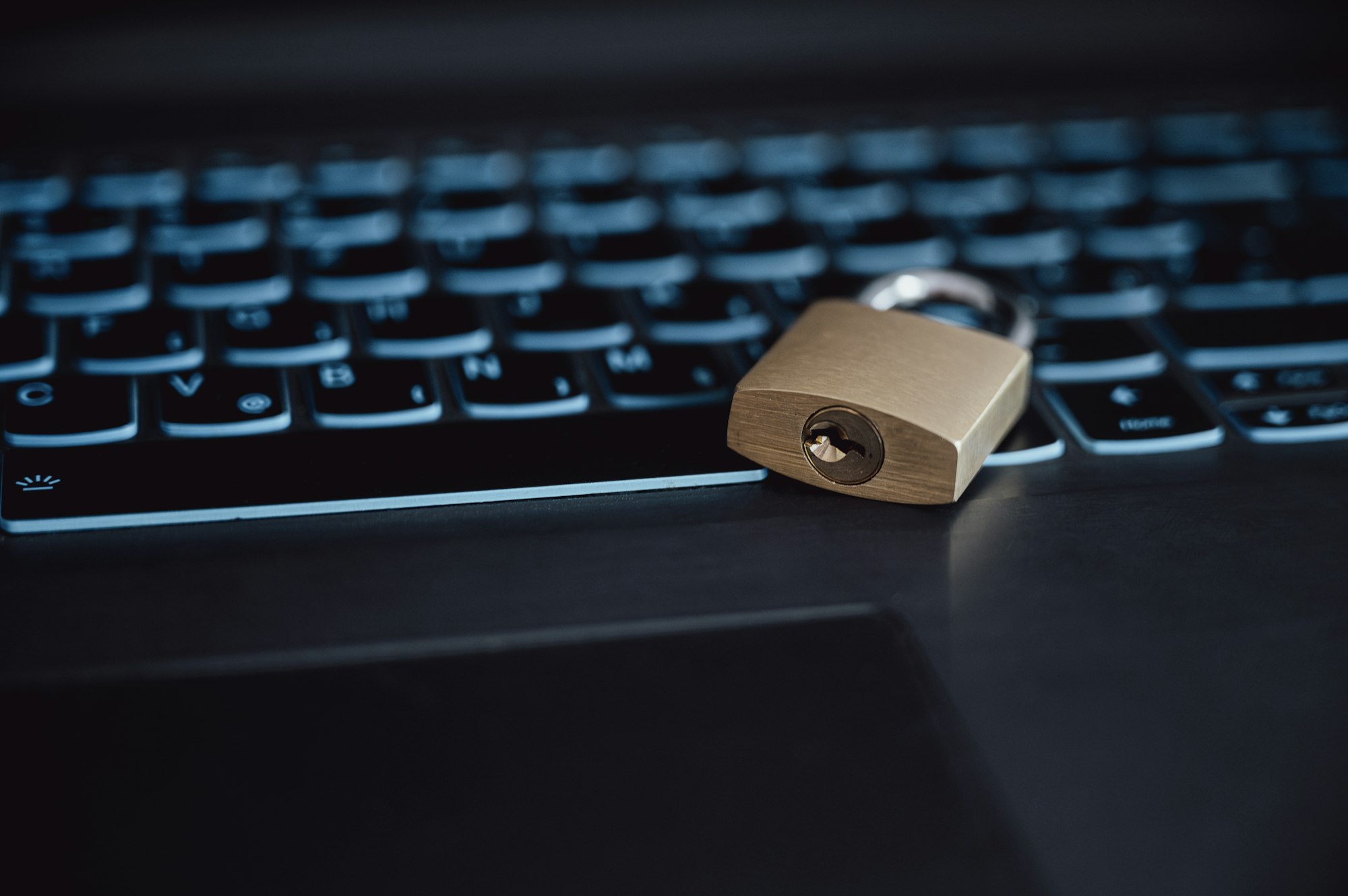 Golden padlock lying on a laptop computer keyboard